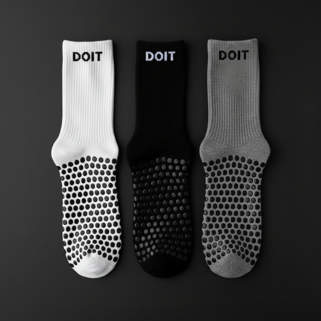 Three pairs of socks in white, black, and gray on a black studio background no text