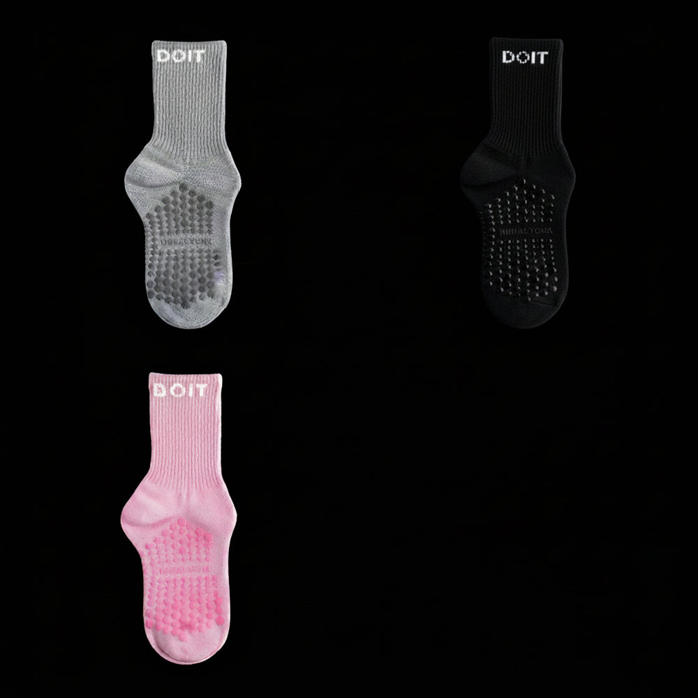 Three pairs of socks in gray, black, and light pink on a stidio black background. removing descriptive text
