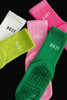Colorful grip socks with 'DO IT' text on a gray surface black studio background