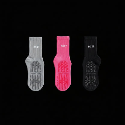 Three pairs of socks in gray, black, and rose red on a studio black  background. removing descriptive text