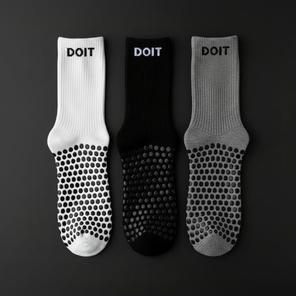Three pairs of socks in white, black, and gray on a black studio background no text